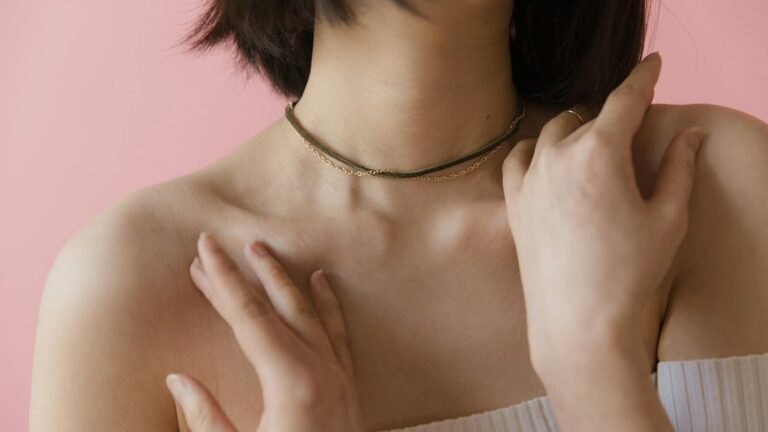 A Woman in White Off Shoulder Shirt Wearing Necklaces